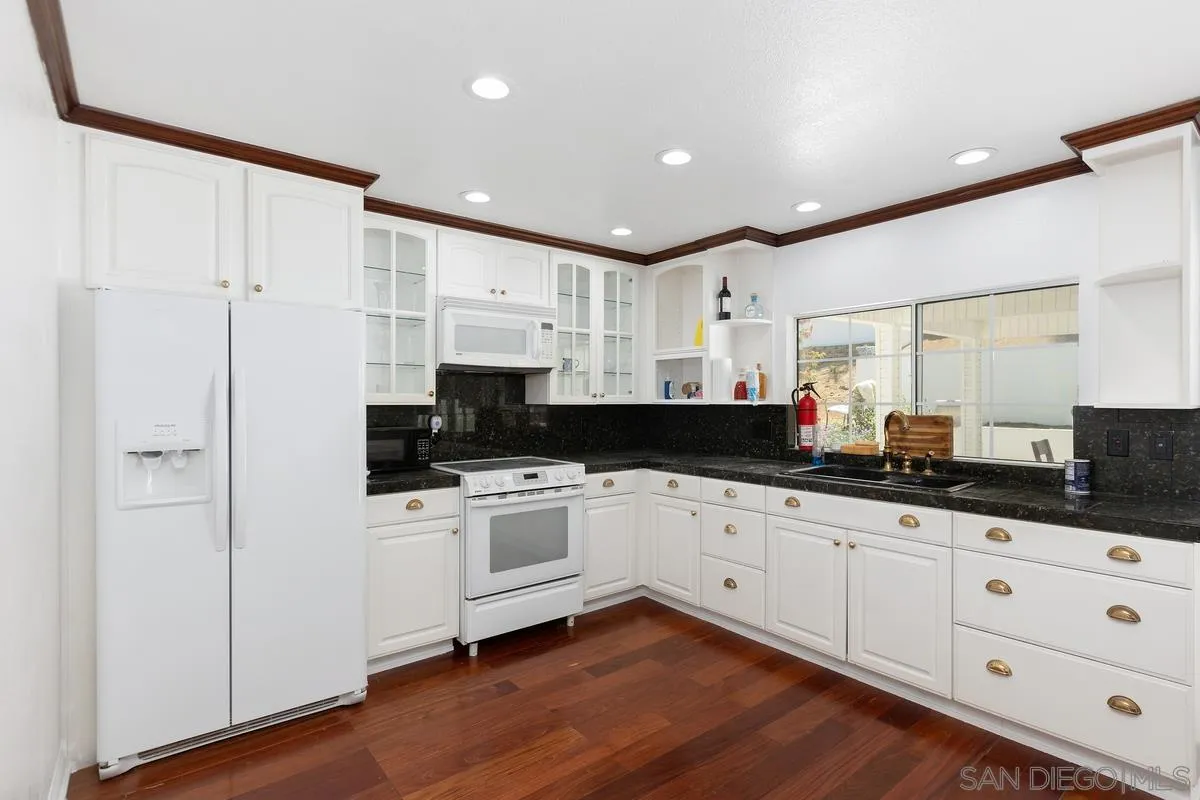 13749 Avenida Del Charro El Cajon, CA 92021 - Photo 8 of 24 a kitchen with granite countertop white cabinets and white appliances