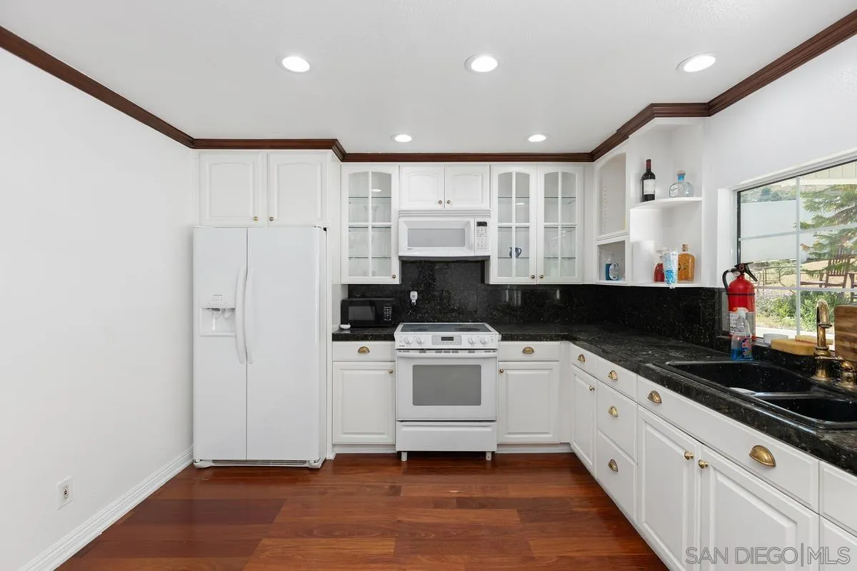 13749 Avenida Del Charro El Cajon, CA 92021 - Photo 9 of 24 a kitchen with white cabinets and appliances
