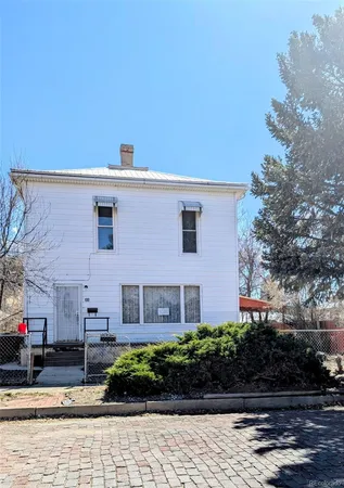 a front view of a house with plants