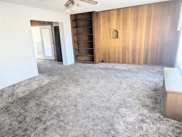 an empty room with a fireplace and cabinet