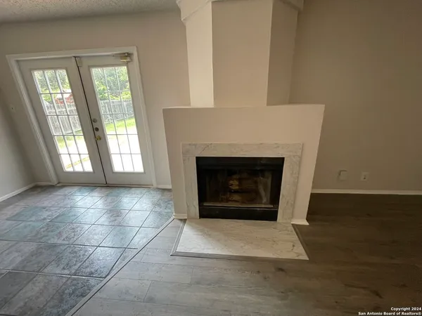 a view of an empty room with a fireplace and a window