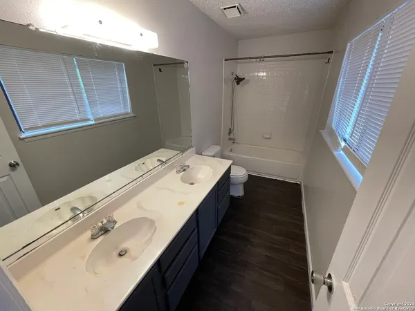 a bathroom with a double vanity sink and mirror with shower
