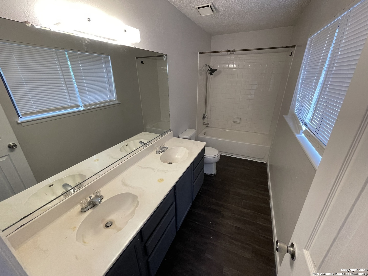9235 Ridge Post San Antonio, TX 78250 - Photo 14 of 30 a bathroom with a double vanity sink and mirror with shower