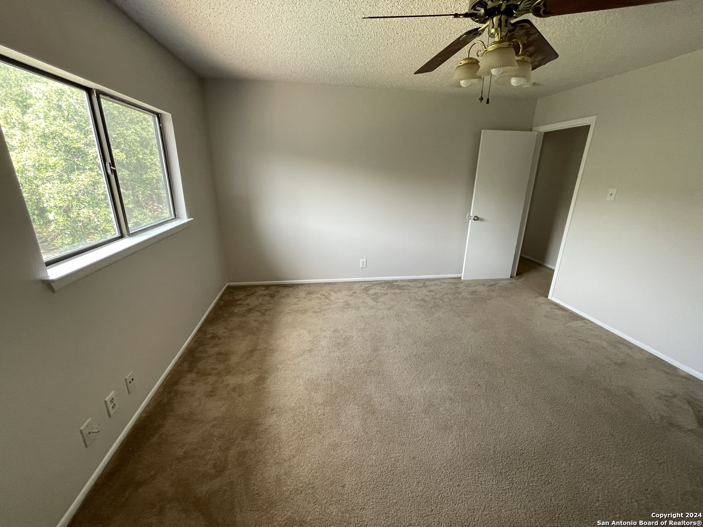 9235 Ridge Post San Antonio, TX 78250 - Photo 23 of 30 en empty room with windows and chandelier