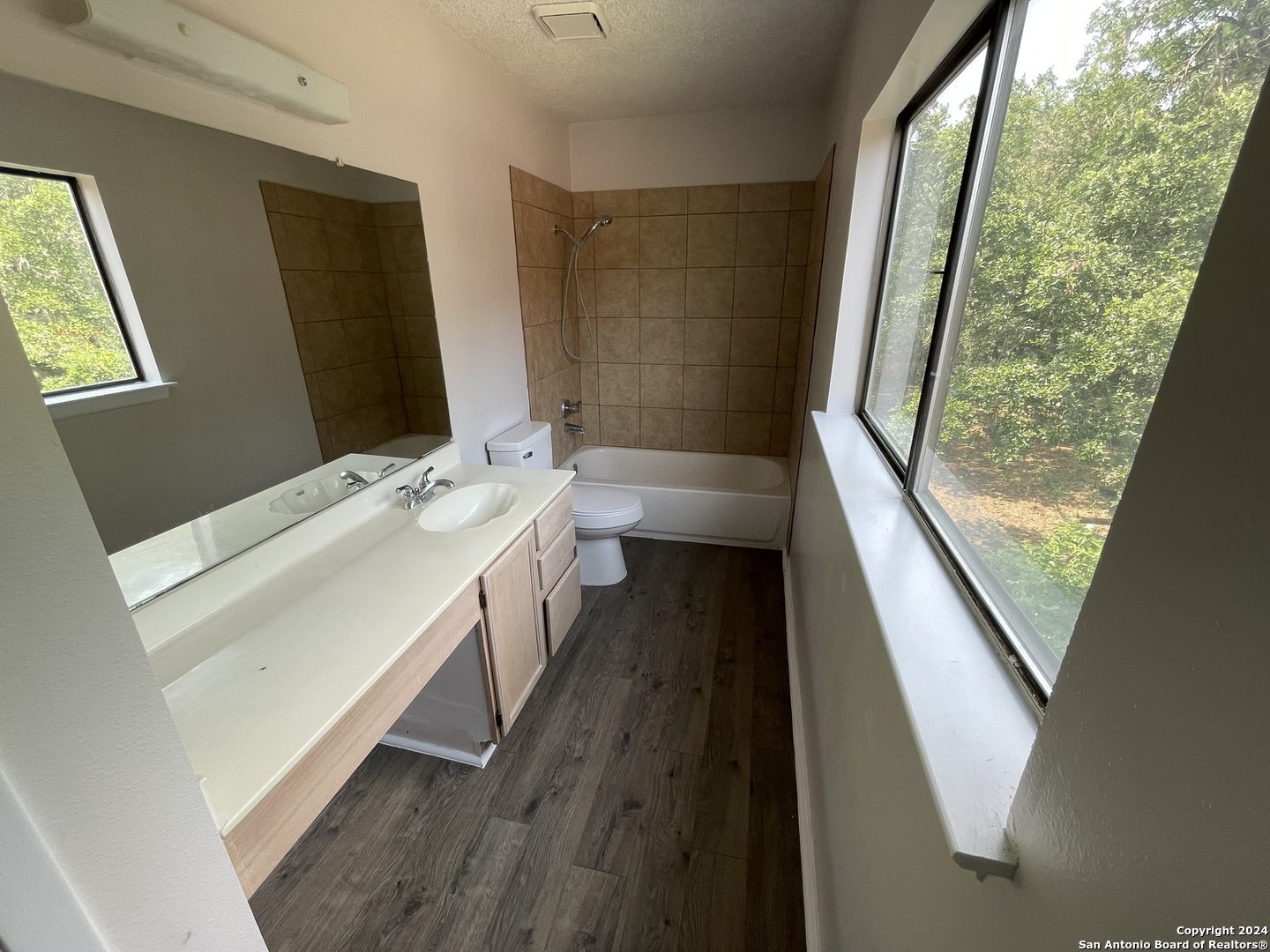 9235 Ridge Post San Antonio, TX 78250 - Photo 25 of 30 a bathroom with a double vanity sink a mirror and a bathtub