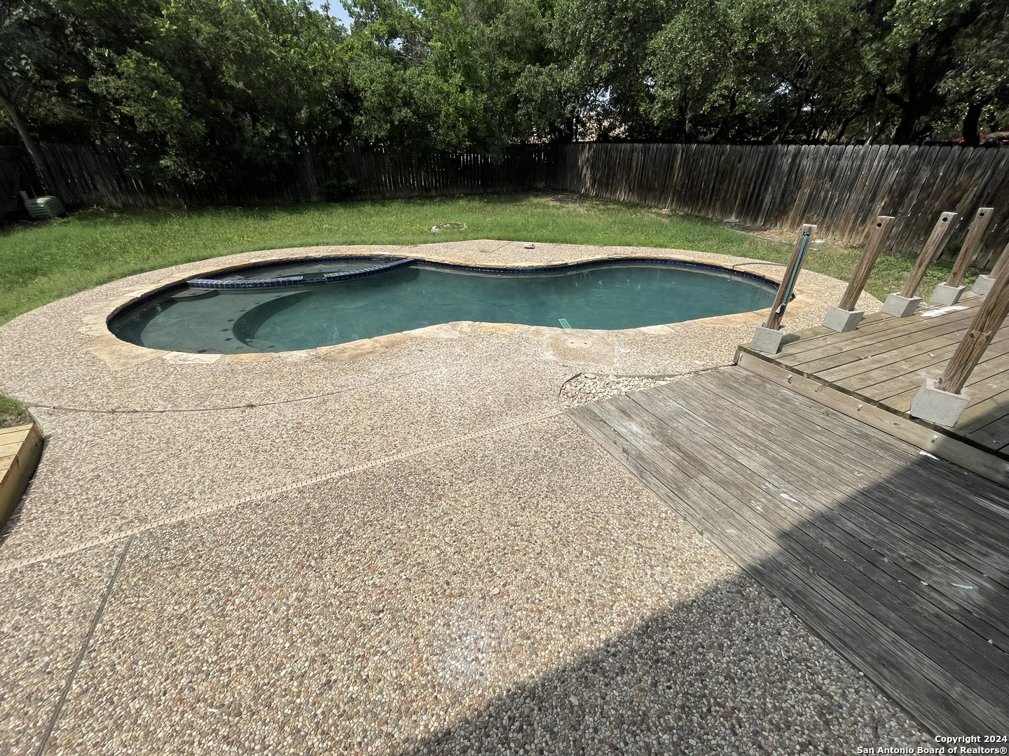 9235 Ridge Post San Antonio, TX 78250 - Photo 27 of 30 a view of a swimming pool and a yard in the background