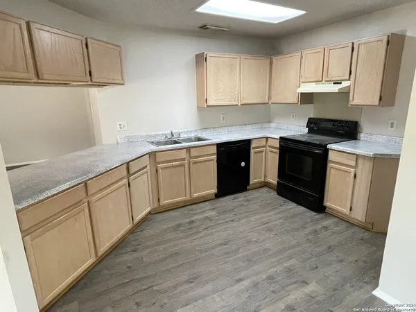 a kitchen with stainless steel appliances granite countertop a stove sink and cabinets