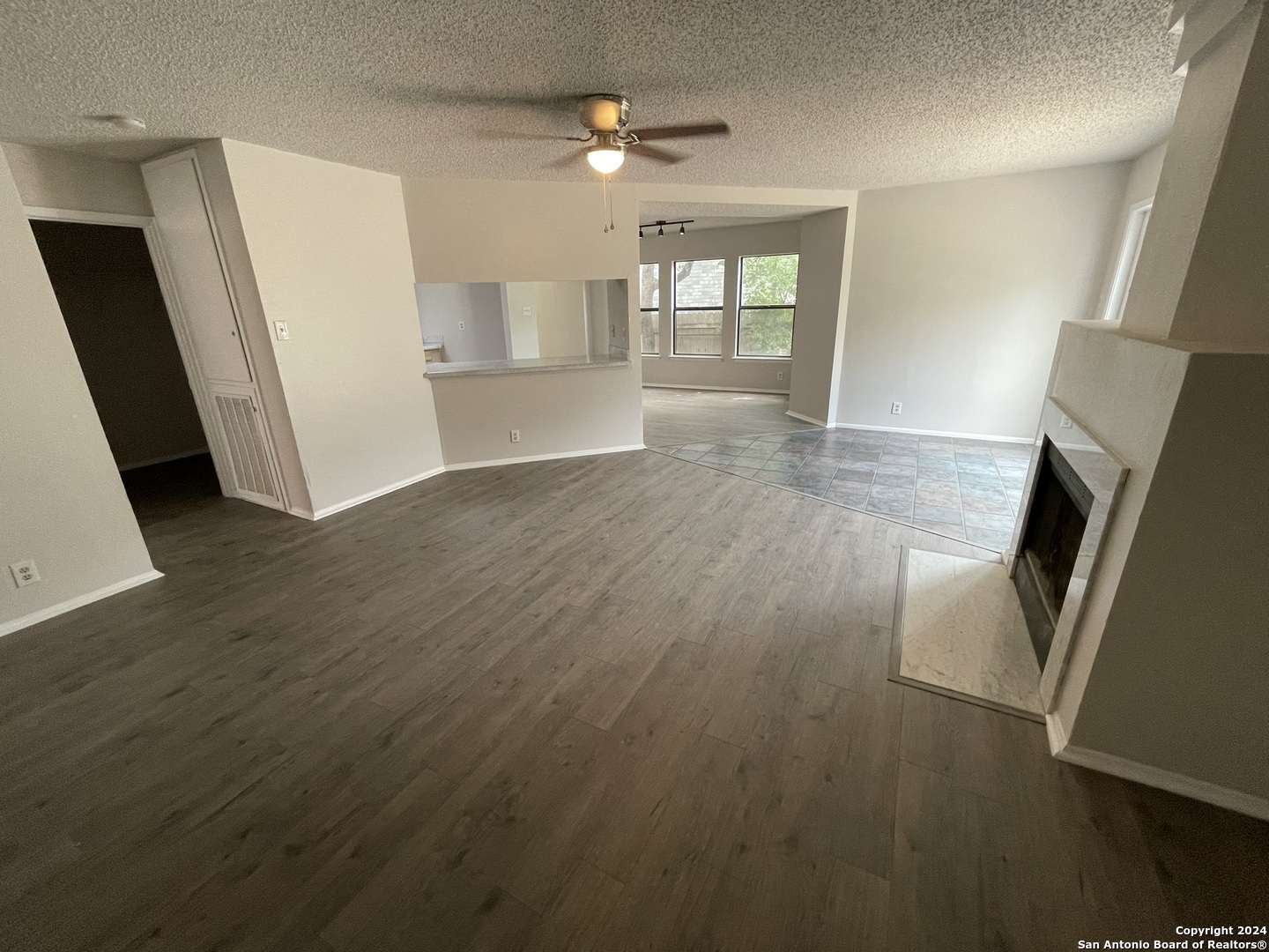 9235 Ridge Post San Antonio, TX 78250 - Photo 10 of 30 an empty room with wooden floor and windows