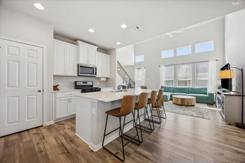 a view of kitchen with microwave stove top oven and cabinets