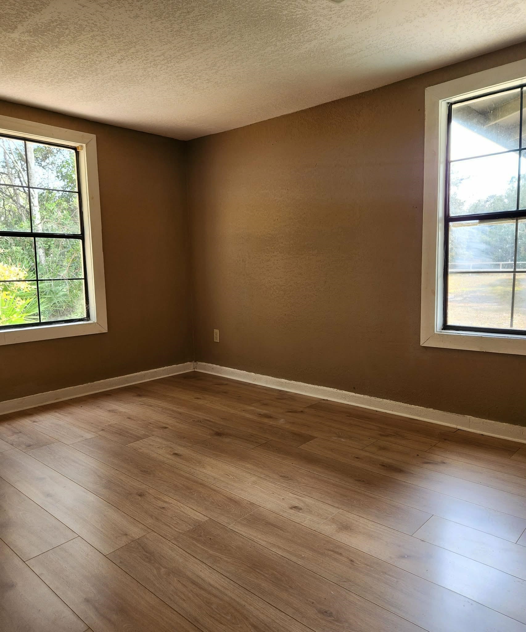 890 Poinsettia Road, Unit B St. Augustine, FL 32086 - Photo 14 of 14 Empty room featuring wood-type flooring and a textured ceiling