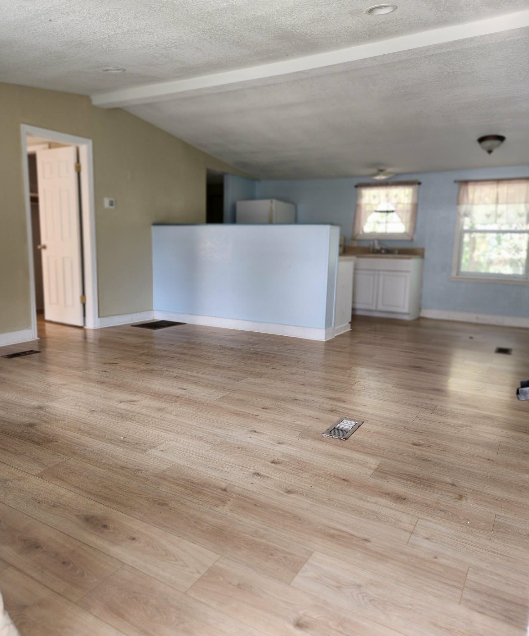 890 Poinsettia Road, Unit B St. Augustine, FL 32086 - Photo 6 of 14 Unfurnished living room with light wood-type flooring and beamed ceiling