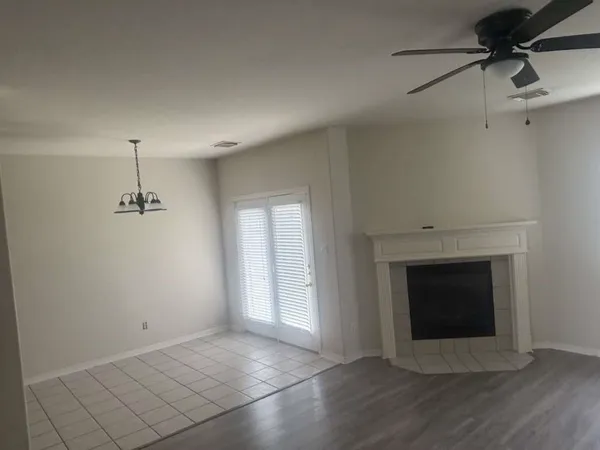 a view of an empty room with a fireplace and a window
