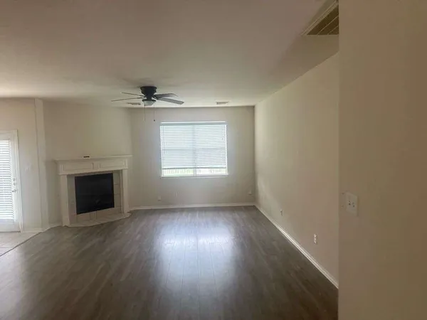 an empty room with windows and fireplace