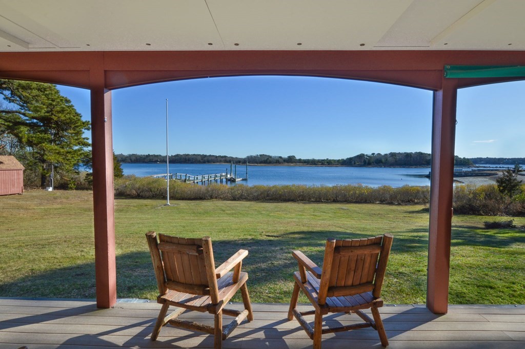 a view of chairs and table in the patio next to a yard