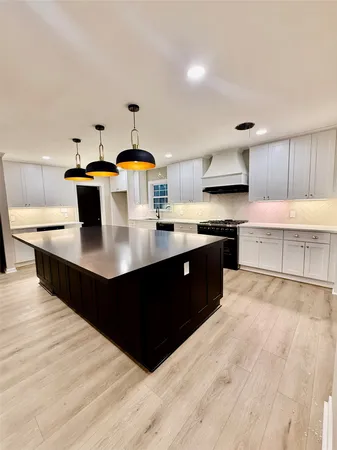 a kitchen with granite countertop white cabinets and stainless steel appliances