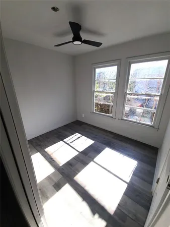 a view of empty room with wooden floor and window