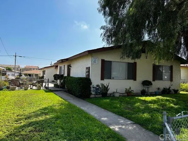 a view of a house with backyard and sitting area