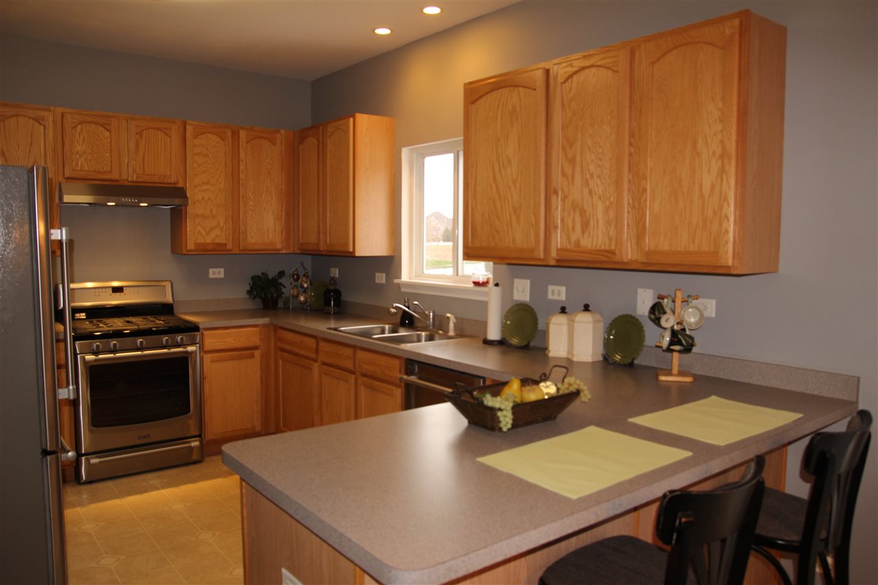 219 Ridgestone Trail Poplar Grove, IL 61065 - Photo 8 of 18 a kitchen with a refrigerator a stove a sink dishwasher and cabinets