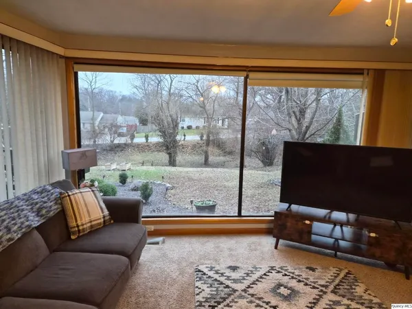 a living room with furniture and a floor to ceiling window