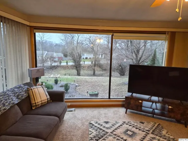a living room with furniture and a floor to ceiling window