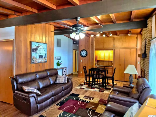 a living room with furniture a chandelier and a flat screen tv