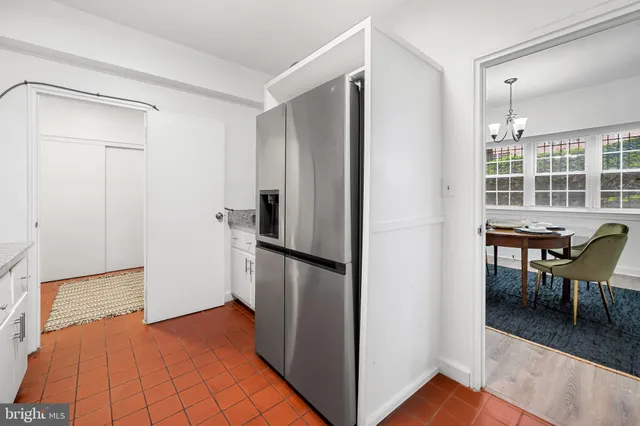 a kitchen with a refrigerator and table chair