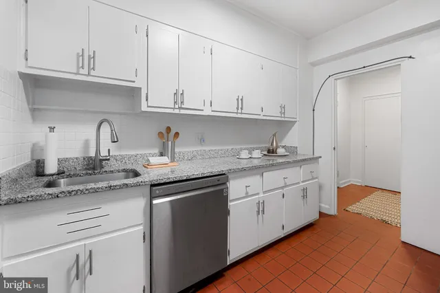 a kitchen with granite countertop white cabinets and white appliances