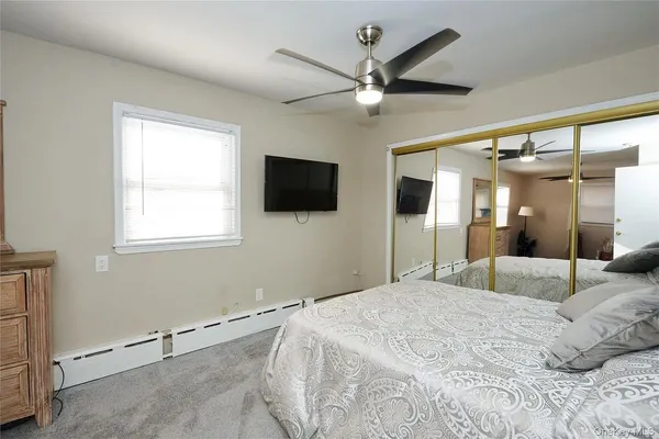 a bedroom with a large bed and a flat screen tv