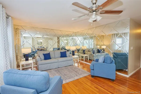 a living room with furniture and a large window with wooden floor