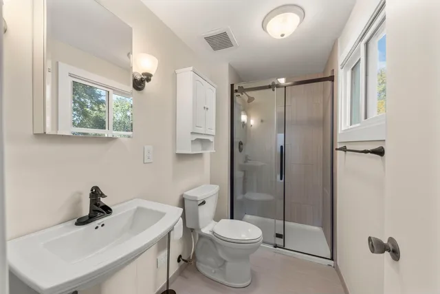 a bathroom with a toilet sink shower and mirror