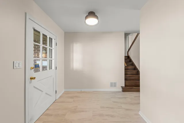 a view of an empty room with stairs and a window