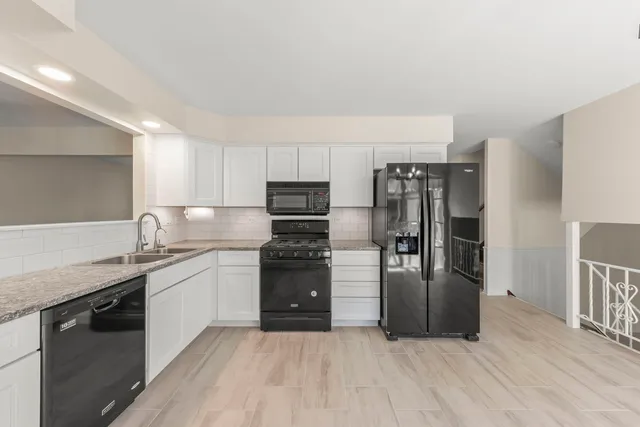a kitchen with stainless steel appliances granite countertop a refrigerator and a stove top oven