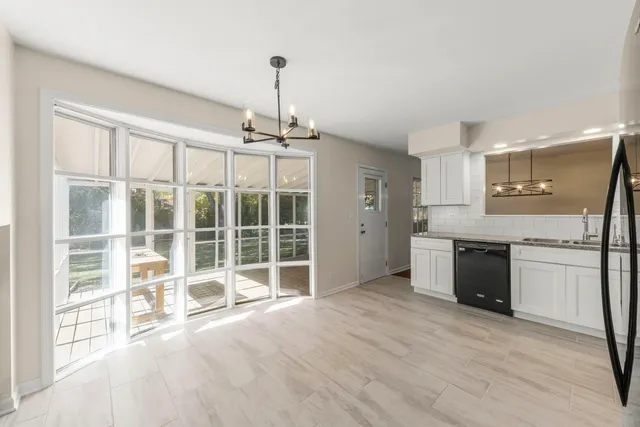 a open kitchen with granite countertop a stove top oven a sink and dishwasher a refrigerator with wooden floor