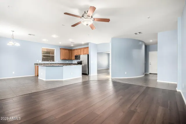 a kitchen with stainless steel appliances granite countertop a refrigerator a sink a stove and a refrigerator