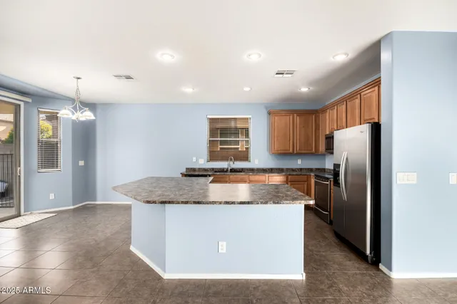 a large kitchen with stainless steel appliances granite countertop a large counter top and a stove