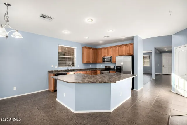 a kitchen with stainless steel appliances granite countertop a stove a sink and a refrigerator