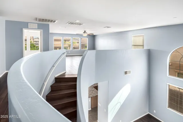 a view of an empty room with a window and a ceiling fan