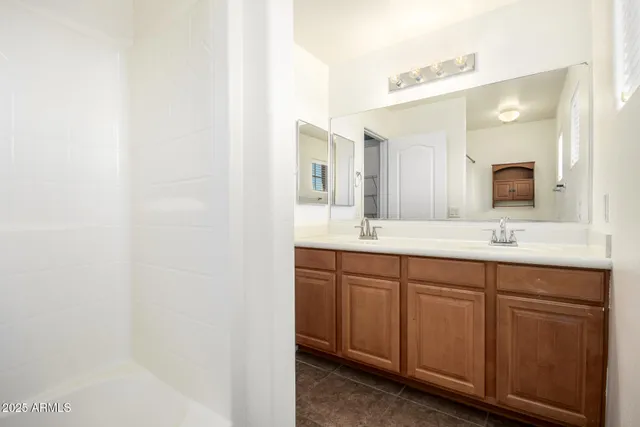 a view of an empty room with wooden floor and a ceiling fan