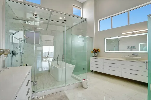 a bathroom with a double vanity sink a toilet a mirror and shower