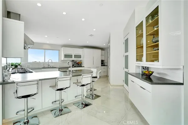 a kitchen with a sink a stove a refrigerator and cabinets