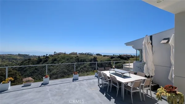 a view of a terrace with furniture and a floor to ceiling window