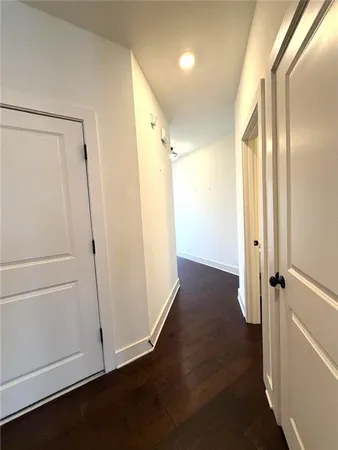 a view of a hallway with wooden floor and cabinet