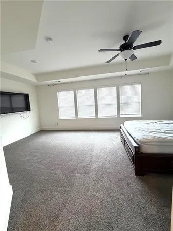 a view of an empty room with a window and a kitchen