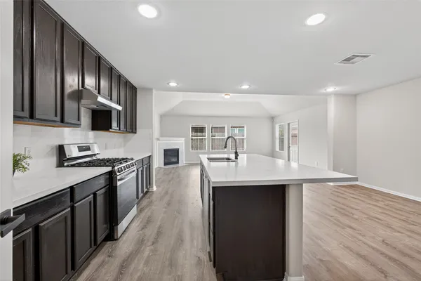a kitchen with stainless steel appliances granite countertop a sink stove and refrigerator
