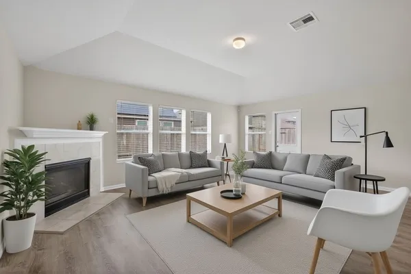 a living room with furniture a fireplace and a potted plant