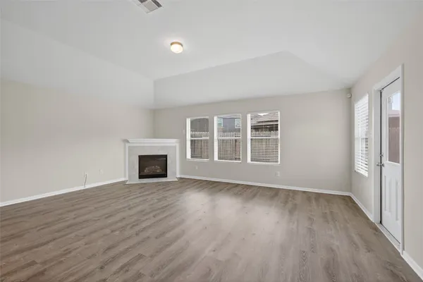 wooden floor fireplace and windows in an empty room