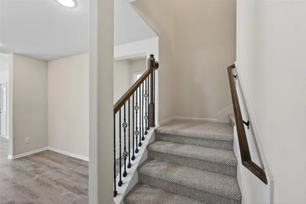 a view of staircase with wooden floor and white walls