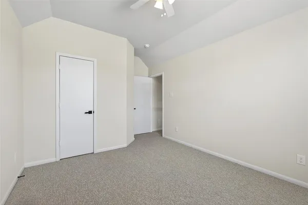 a view of an empty room with closet and mirror