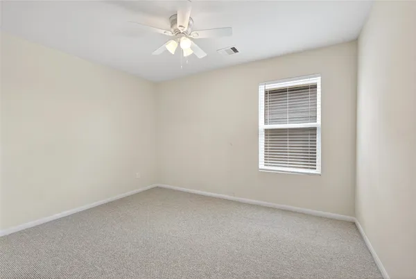 a view of a room with a ceiling fan and a window