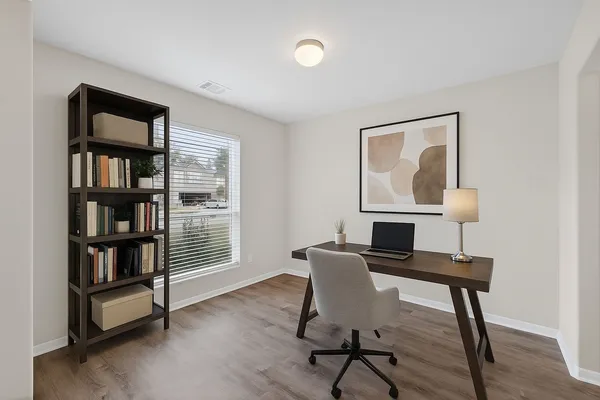 a view of a workspace with furniture and a window